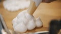 Cooking pavlova dessert meringue - pastry tube spread meringue on a baking sheet Royalty Free Stock Photo