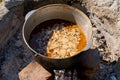 Cooking pilaf in a large cauldron over an open fire. Close-up Royalty Free Stock Photo