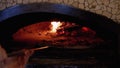 Cooking Pizza in an Italian Woodfired Clay Oven in a Restaurant