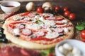 Cooking pizza with tomatoes, sprinkle with grated cheese close up Royalty Free Stock Photo
