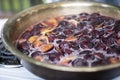 Cooking plum jam with lemon and spices in copper basin on a gas stove. Wide frame Royalty Free Stock Photo