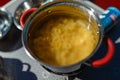 Cooking on a portable gas stove, on a folding table in the background of camping in the woods. Spaghetti in a pot on a gas burner Royalty Free Stock Photo