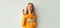 Cooking, portrait of happy smiling young woman housewife holding plate with stack of pancakes with strawberries on gray wall