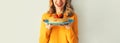 Cooking, portrait of happy smiling young woman housewife holding plate with stack of pancakes with strawberries on gray wall