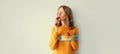 Cooking, portrait of happy young woman enjoying tasty fresh strawberry holding plate with stack of pancakes on gray wall