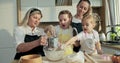 Cooking preparing process. Elderly granny holding sieve in hands taking flour to sieve on glass bowl curious offsprings