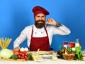 Cooking process concept. Cook with smile in burgundy uniform Royalty Free Stock Photo