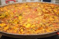 Paella in a huge frying pan. The cooking process.