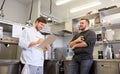 Happy smiling chef and cook at restaurant kitchen Royalty Free Stock Photo