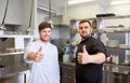 Chefs at restaurant kitchen showing thumbs up