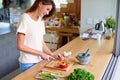 Cooking in progress. an attractive young woman chopping vegetables in a kitchen. Royalty Free Stock Photo