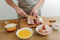 Cooking in progress. Meat,eggs, flour, salt on the table, cutting board and knife