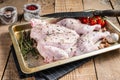 Cooking Raw spatchcocked whole chicken with garlic and thyme in baking dish. Wooden background. Top view Royalty Free Stock Photo