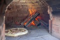 Cooking real pizza in a brick oven. Wood and fire are burning Royalty Free Stock Photo