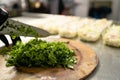 cooking in a restaurant, chef& x27;s hand cutting greens on a wooden board, vegan salad with parsley, vegetable food Royalty Free Stock Photo