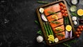 Cooking salmon with asparagus, lemon and vegetables in a metal baking dish. Seafood. Royalty Free Stock Photo