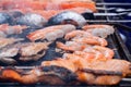 Cooking salmon, tiger shrimp, prawn skewers and mackerel fish on grill: close up Royalty Free Stock Photo