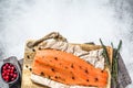 Cooking salted salmon fillet on a wooden cutting Board with herbs and spices. Gray background. Top view. Copy space