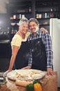Cooking, smile and portrait of senior couple in kitchen at home with dough, flour and ingredients for meal. Happy, food Royalty Free Stock Photo