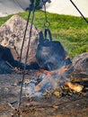 Cooking soup over burning campfire Royalty Free Stock Photo