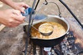 Cooking soup over campfire in hike Royalty Free Stock Photo