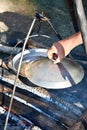 Cooking soup in the stowed bowler over campfire Royalty Free Stock Photo