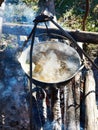 Cooking soup in the stowed bowler over campfire Royalty Free Stock Photo