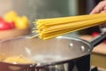 Cooking Spaghetti: A hand lowering uncooked pasta into a pot of boiling water Royalty Free Stock Photo