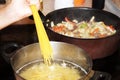 Cooking spaghetti and vegetable stew with meat in a saucepan close-up Royalty Free Stock Photo