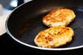 Cooking steak from fresh meat. Two meatballs fried in a metal pan. Close-up Royalty Free Stock Photo