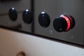 Cooking stove, macro shot, rotary knob glows red and stands on level three, focused on the knob