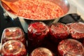 Cooking strawberry jam in a large bowl at home. Wooden spoon in a bowl with jam. Empty glass jam jars and jars filled with jam. Royalty Free Stock Photo