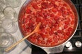 Cooking strawberry jam in a large bowl at home. Wooden spoon in a bowl with jam. Empty glass jars for jam. Royalty Free Stock Photo