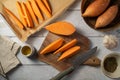 Cooking sweet potato wedges, raw sweet potatoes sliced on cutting board. Royalty Free Stock Photo