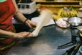 Cooking sweet Thai pancakes. A female cook on the street rolls and turns the dough, close-up of the hand. traditional Royalty Free Stock Photo