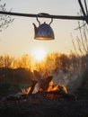 Cooking tea on a fire in a kettle at sunset