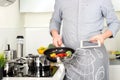 Cooking, technology and home concept - closeup of man pointing finger to tablet pc computer Royalty Free Stock Photo