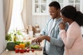 Cooking Together. Portrait of happy affectionate black couple preparing lunch in kitchen Royalty Free Stock Photo
