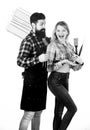Cooking together. Tools for roasting meat outdoors. Picnic and barbecue. Bearded hipster and girl ready for barbecue Royalty Free Stock Photo