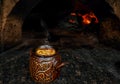 Cooking traditional baked soup in a clay pot in the hearth, over an open fire in a cafe. Lamb guvech with vegetables in a Turkish Royalty Free Stock Photo