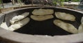 Cooking traditional lavash in national oven for making a bread in Georgia. stone oven for baking a Georgian bread. Royalty Free Stock Photo