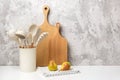 Cooking utensil set on kitchen table. Silicone kitchen tools, wooden cutting boards, mortar bowl with pestle. Front view Copy
