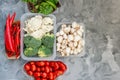 Cooking vegan food with raw vegetables. Broccoli and cauliflower, pepper and champignons for a vegetable dish in a plastic Royalty Free Stock Photo