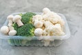 Cooking vegan food with raw vegetables. Broccoli and cauliflower, pepper and champignons for a vegetable dish in a plastic Royalty Free Stock Photo