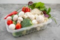 Cooking vegan food with raw vegetables. Broccoli and cauliflower, pepper and champignons for a vegetable dish in a plastic Royalty Free Stock Photo