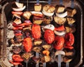 Cooking vegetables on grill outdoors. Grilled veggie skewers. Barbecue and picnic season concept. Top view Royalty Free Stock Photo