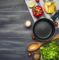 Cooking a vegetarian dinner, red and yellow bell peppers, salad, wooden spoon, cherry tomatoes, condiments,lime, black cooking pot Royalty Free Stock Photo