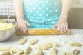 Cooking vegetarian dumplings with mashed potatoes kreplach, jewish ravioli in home kitchen. Female hands rolling dough`s circle Royalty Free Stock Photo