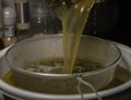 Cooking of yellow and green marijuana butter in hot water in kitchen Royalty Free Stock Photo