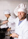 Cooks cooking at professional kitchen Royalty Free Stock Photo